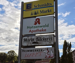 Ein Schild, auf dem die Geschäfte des Ortkerns genannt werden.